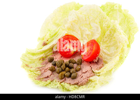 Pate de viande avec les câpres et les tomates sur des feuilles de laitue. Banque D'Images