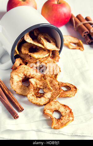 La cannelle biologique de pommes frites (tranches) en métal mug sur fond blanc - végétarien végétalien sains collations aux fruits ou un ingrédient pour la cuisine Banque D'Images