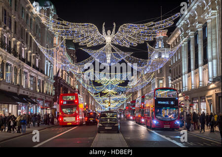 Londres - le 18 novembre 2016 : taxi noir traditionnel vous attend les clients en vertu de l'allumage des anges de Noël scintillantes Regent Street. Banque D'Images