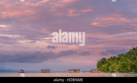 Coucher de soleil sur le quai de la gare de plongée et sur l'Habitant de l'Île Kri, Raja Ampat, Indonésie, Papouasie Occidentale Banque D'Images