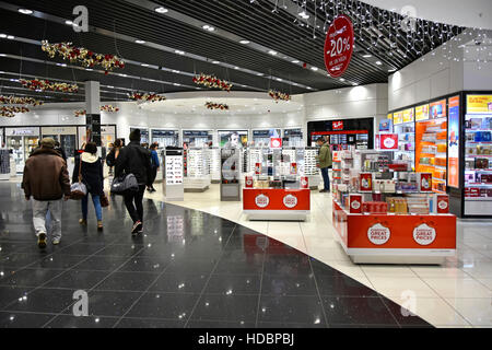 Passagers d'avion du terminal de l'aéroport de Stansted à l'aéroport de Londres à pied dans le centre commercial de détail en route vers le salon de départ Essex Angleterre Royaume-Uni Banque D'Images