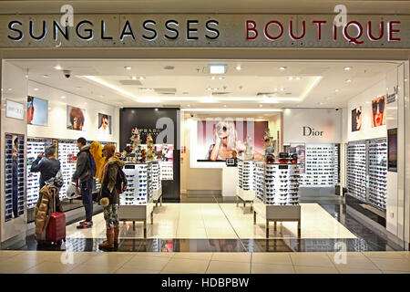 Les voyageurs à l'aéroport de Stansted Londres shopping Boutique de lunettes de soleil à côté de départ des aéroports de l'intérieur de l'aérogare Essex England uk Banque D'Images