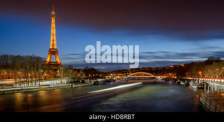 La Tour Eiffel illuminée au crépuscule avec des berges de la Seine et la passerelle Debilly. Paris, France Banque D'Images
