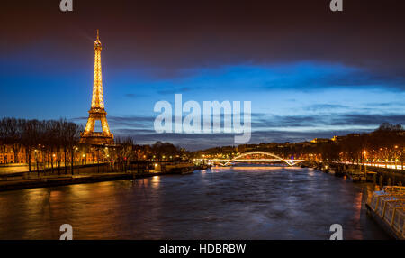 La Tour Eiffel illuminée au crépuscule avec des berges de la Seine et la passerelle Debilly. Paris, France Banque D'Images