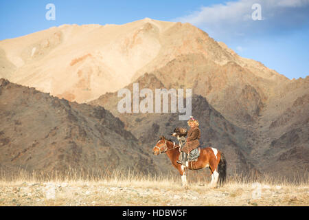 Bayan Ulgii, la Mongolie, le 2 octobre, 2015 : Old eagle hunter avec son aigle d'Altaï sur son cheval Banque D'Images