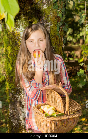 Jeune adolescent avant de manger dans le jardin d'apple avec panier Banque D'Images