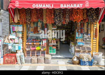 BODRUM, TURQUIE - 6 octobre, 2016 : Brins de piments séchés accrocher la décoration de l'avant d'un magasin de vente d'épices, et les huiles de cuisson. Banque D'Images