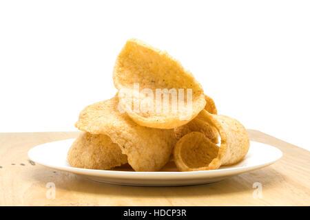 Pile de crevettes croustillantes dans cracker une plaque blanche sur une planche en bois sur fond blanc Banque D'Images