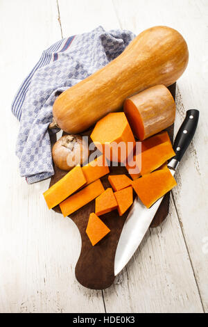 Potiron butternut pelée sur une planche en bois Banque D'Images