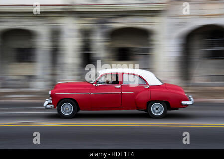 1950 rouge voiture américaine le long du Malecon, La Havane, Cuba. Banque D'Images