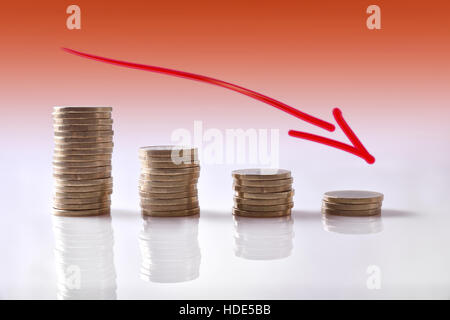 Graphique à la baisse d'activité représentés avec des pièces le tableau réfléchissant blanc et orange dégradé arrière-plan. Composition horizontale. Vue avant Banque D'Images