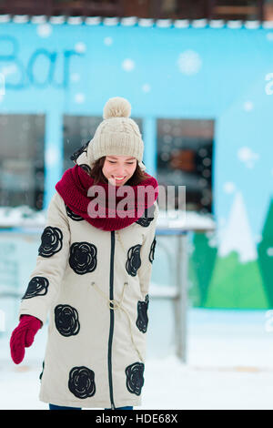 Happy young girl patinage sur une patinoire en plein air Banque D'Images