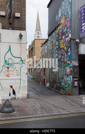 Brick Lane à la ruelle vers Christ Church Spitalfields complexes avec des graffitis sur les murs. Banque D'Images