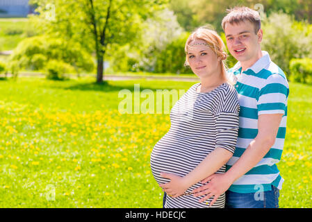 L'homme et la femme dans T-shirts à rayures en attente de reconstitution de la famille Banque D'Images
