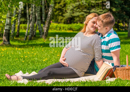 Les gens qui s'aiment sont en attente d'un bébé, un pique-nique dans le parc d'été Banque D'Images