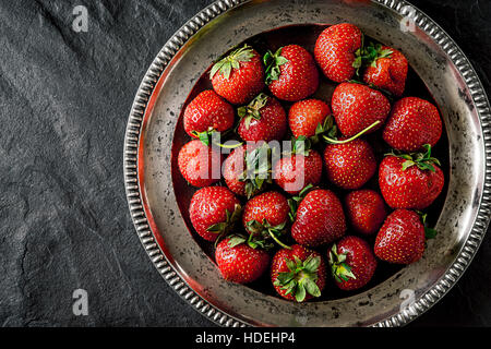 Fraise à l'ancienne plaque métallique sur la pierre noire Vue de dessus de table Banque D'Images