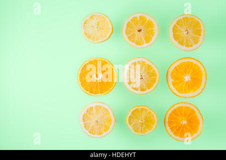 Tranches de citron et d'orange sur fond bleu clair, vue d'en haut Banque D'Images
