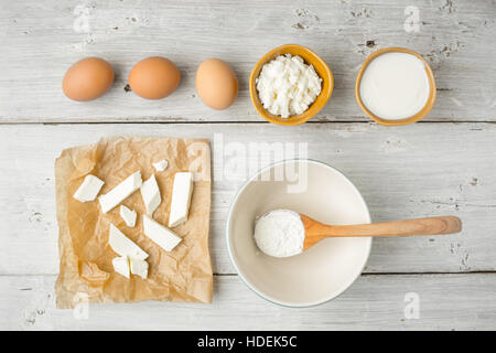 Différents fromages frais avec du yaourt et des oeufs sur la vue de dessus de table en bois blanc Banque D'Images