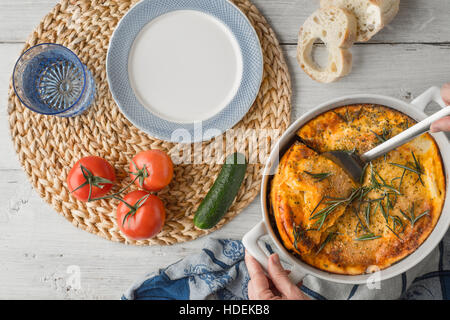 La Moussaka dans le tableau blanc avec vaisselle et légumes vue supérieure Banque D'Images