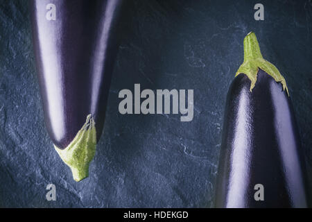 Aubergines sur la pierre sombre vue de dessus d'arrière-plan Banque D'Images