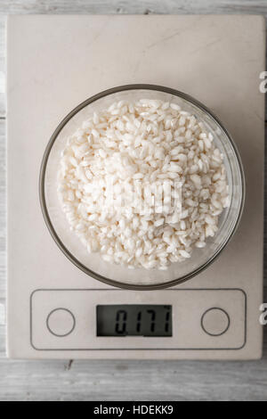 Le riz dans le bol en verre sur l'échelle à la verticale Banque D'Images