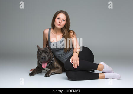 Belle fille avec Stafford Terrier gris Banque D'Images