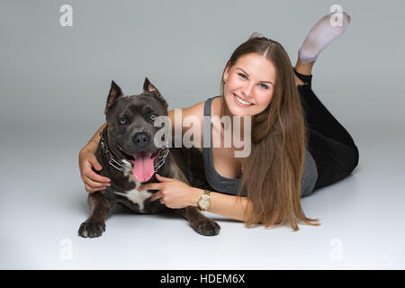 Belle fille avec Stafford Terrier gris Banque D'Images