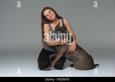 Belle fille avec Stafford Terrier gris Banque D'Images