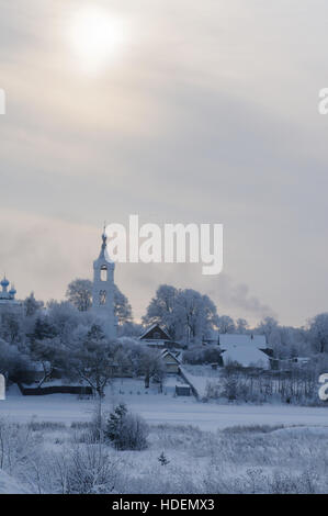 Vue sur un village avec église couverte de neige sur un jour froid sur une petite rivière, la rivière Nerl Porechye, village, région de Tver, Russie Banque D'Images