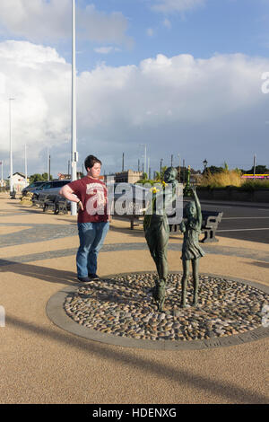 Jeune homme sur la Esplenade, Fleetwood, affichage de la sculpture 'Welcome Home' par Anita Lafford. Banque D'Images