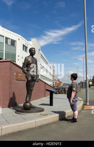 Jeune homme d'admirer la statue de Jimmy Structure, ancien joueur et capitaine de Blackpool Football Club. Banque D'Images