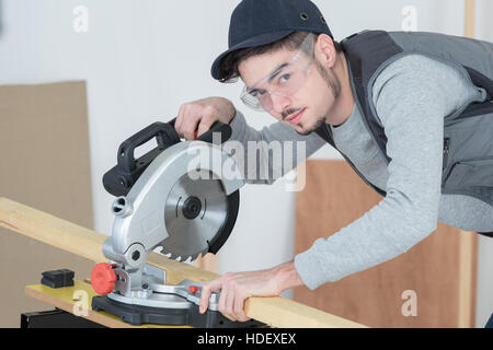 Jeune homme à l'aide de scie circulaire Banque D'Images