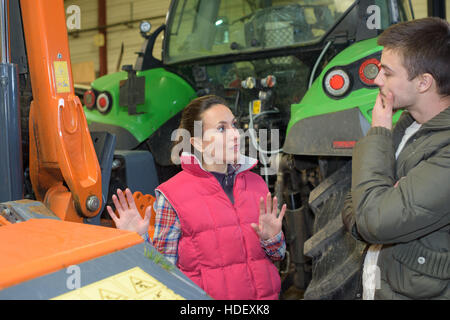 Jolie femme vendant tout nouveau tracteur pour agriculteur débutant Banque D'Images