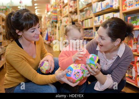 Mère et fille avec des forfaits en magasin de jouets Banque D'Images