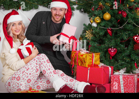 Heureux les jeunes avec des cadeaux near Christmas Tree Banque D'Images
