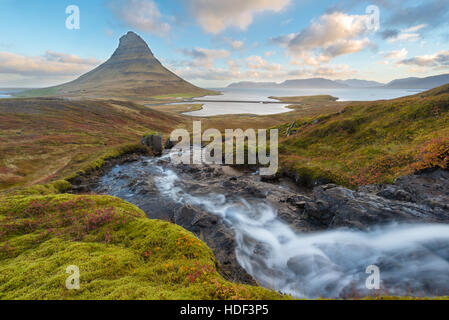 Haut de la sunrise incroyable chute d'Kirkjufellsfoss avec Kirkjufell mountain en arrière-plan sur la côte nord de l'Islande. Banque D'Images