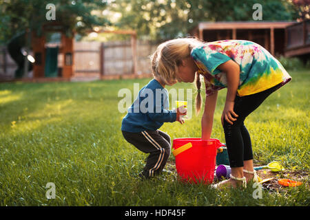 Beau garçon et fille sur l'aire de jeux sur l'herbe. Banque D'Images