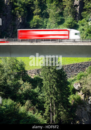 Un chariot est conduite sur un pont routier de l'autoroute suisse A2 vers le tunnel du Gothard à travers les Alpes suisses. Banque D'Images