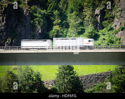 Un chariot est conduite sur un pont routier de l'autoroute suisse A2 vers le tunnel du Gothard à travers les Alpes suisses. Banque D'Images