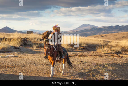 Bayan Ulgii, la Mongolie, le 2 octobre, 2015 : Old eagle hunter avec son aigle d'Altaï sur son cheval Banque D'Images