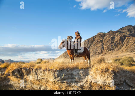 Bayan Ulgii, la Mongolie, le 2 octobre, 2015 : Old eagle hunter avec son aigle d'Altaï sur son cheval Banque D'Images