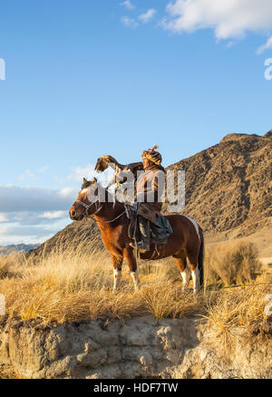 Bayan Ulgii, la Mongolie, le 2 octobre, 2015 : Old eagle hunter avec son aigle d'Altaï sur son cheval Banque D'Images