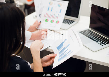 L'équipe d'analyse de graphes de revenu avec les ordinateurs portables modernes. Analyse et stratégie Close up concept. Banque D'Images