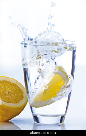 Chute de citron dans un verre d'eau Banque D'Images