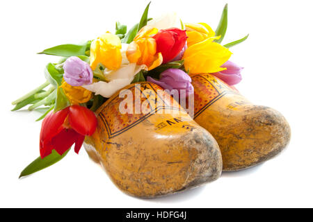 Dutch des chaussures en bois avec tulipes colorées sur fond blanc Banque D'Images