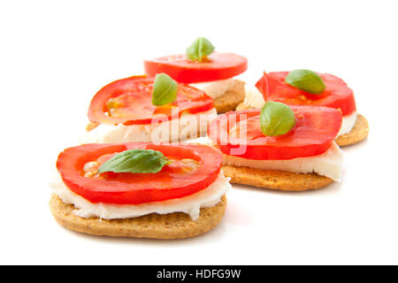 Toast avec du fromage tomate et basilic isolated over white Banque D'Images