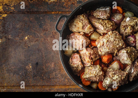 La viande avec les légumes dans la poêle sur le fond métallique Banque D'Images