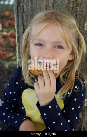 L'âge scolaire adorable girl eating sandwich au beurre d'arachide et confiture Banque D'Images