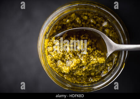 Sauce Pesto dans le bocal en verre avec cuillère vue supérieure Banque D'Images