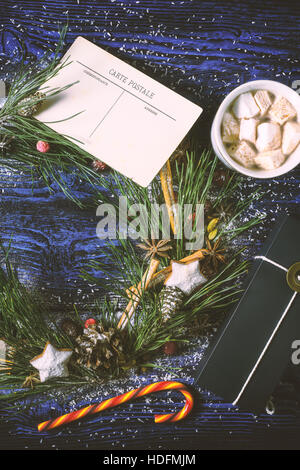 Couronne de Noël avec carte postale et présent sur le fond de bois à la verticale Banque D'Images